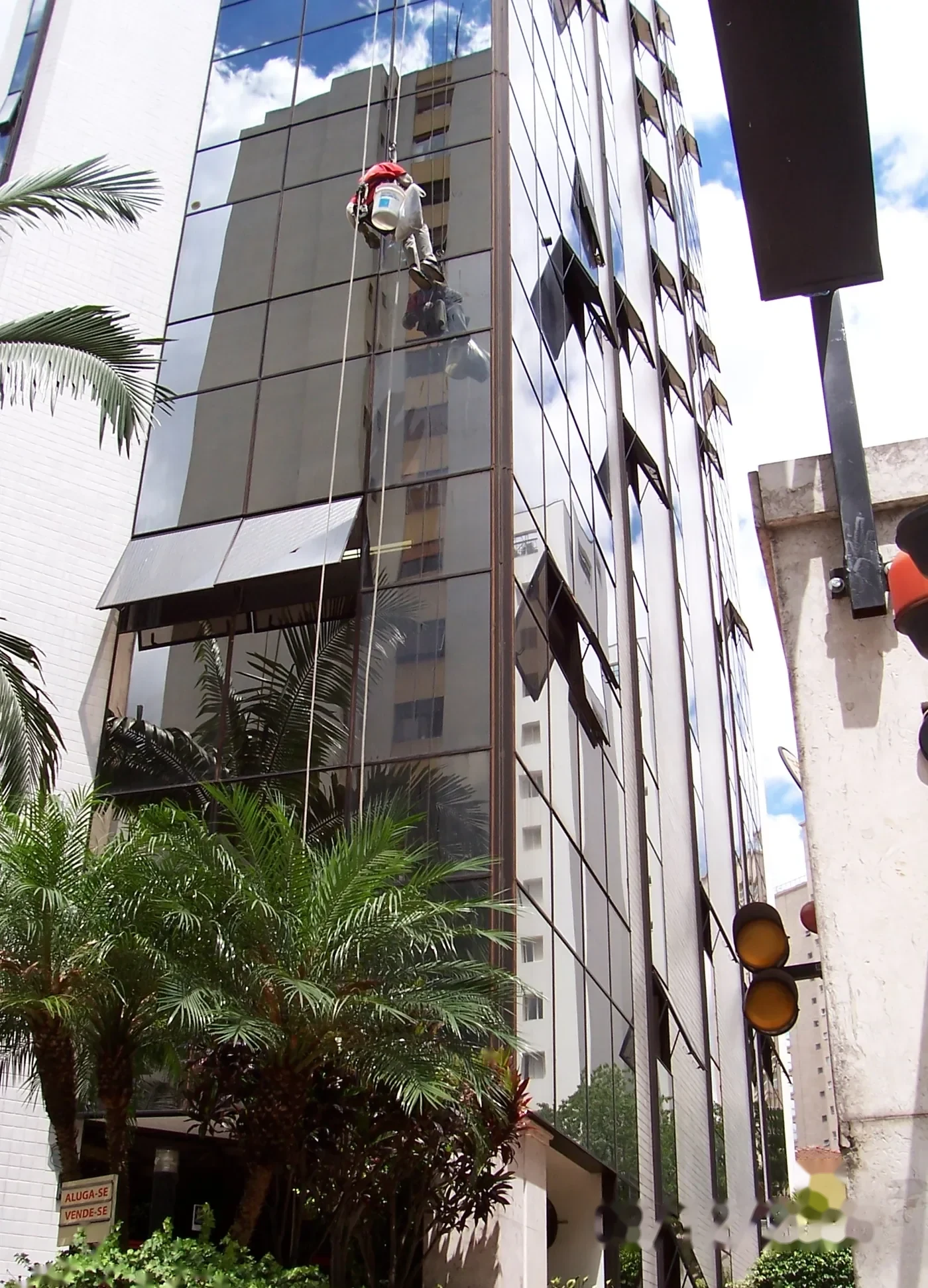 Alpinista industrial em serviço na fachada espelhada de edifício em São Paulo — foto 3